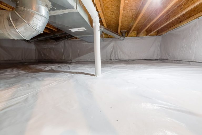 a white plastic sheet laid out in a crawl space